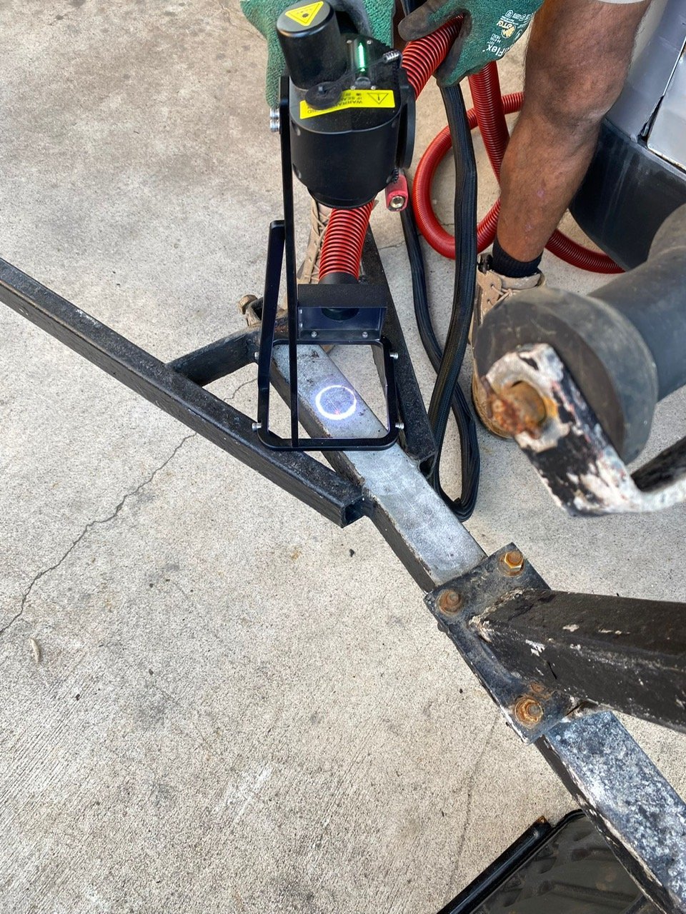 Vacuum hose capturing debris at the laser head